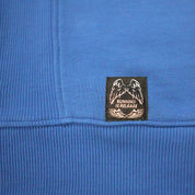 Close-up of a blue fabric with a black label featuring white text and graphics.