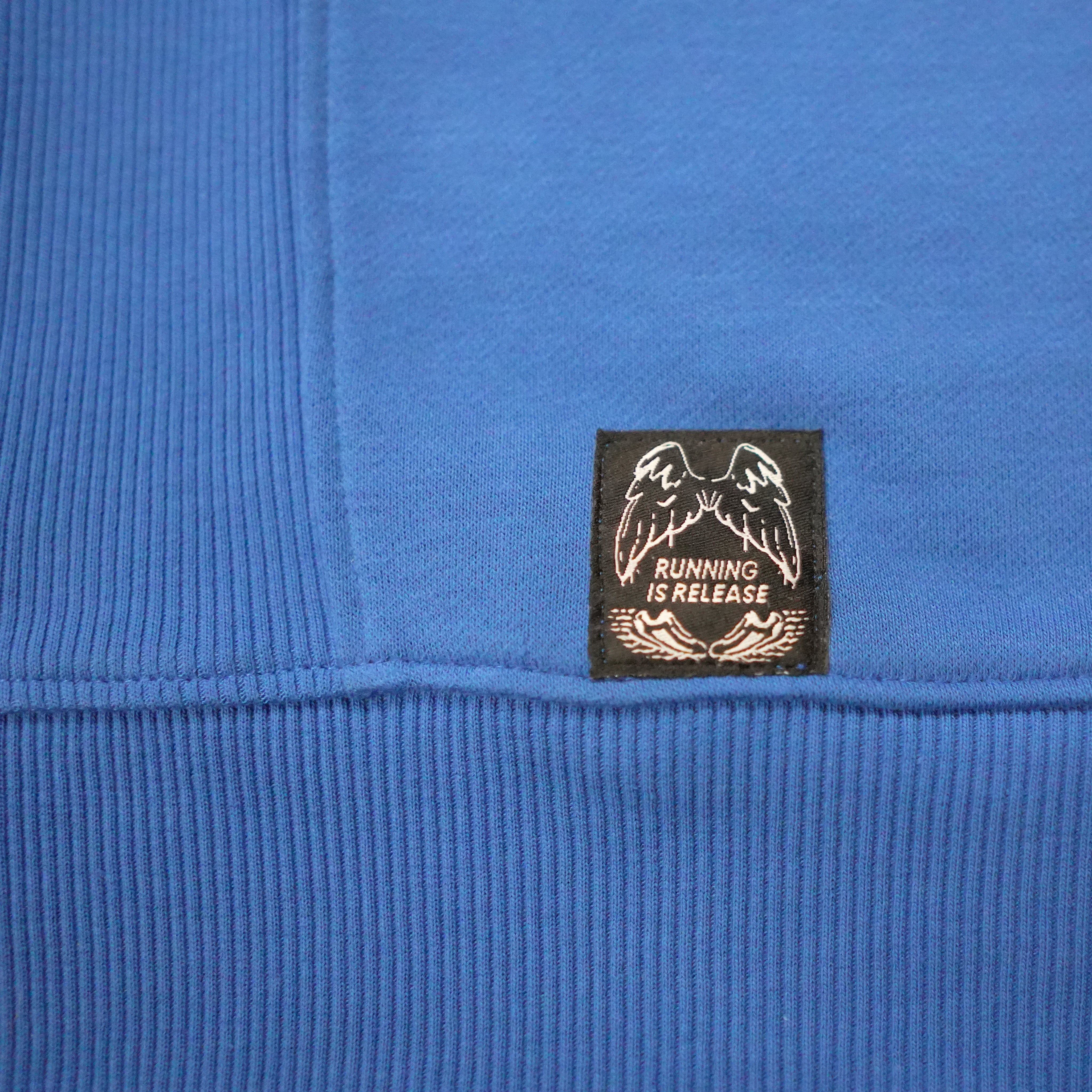 Close-up of a blue fabric with a black label featuring white text and graphics.